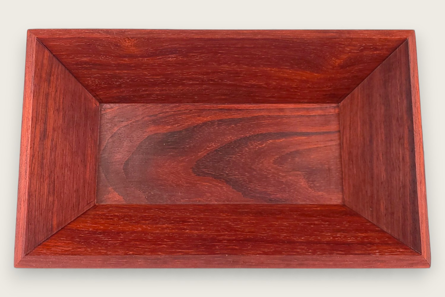 Padauk catch-all bowl with horizontal face grain, rectangular shape, warm reddish tones, and a tung oil finish.